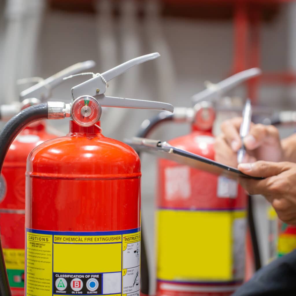 Engineer are checking and inspection a fire extinguishers tank in the fire control room for safety training and fire prevention.